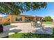 Backyard with stone tile patio, outdoor furniture, artificial grass, and mature trees at 42043 N Bradon Way, Phoenix, AZ 85086