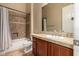 This bathroom features tile flooring, a single sink vanity, and a shower-tub combo with tiled walls at 42043 N Bradon Way, Phoenix, AZ 85086