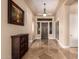 Elegant home foyer with travertine floors, tray ceiling, and a decorative wood front door at 42043 N Bradon Way, Phoenix, AZ 85086