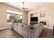 Comfortable living room featuring a large sectional sofa, fireplace, and a big window view of the backyard at 42043 N Bradon Way, Phoenix, AZ 85086