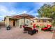 This backyard features artificial turf, a fire pit, paver patio and outdoor seating area at 42577 W Rosalia Dr, Maricopa, AZ 85138