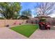 This backyard features artificial turf, a paver patio, seating area and decorative landscaping at 42577 W Rosalia Dr, Maricopa, AZ 85138