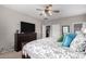 Relaxing bedroom with a ceiling fan, dresser, and a comfortable bed with stylish pillows and bedding at 42577 W Rosalia Dr, Maricopa, AZ 85138