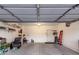 The garage is spacious, with a door, concrete flooring, shelving and an overhead door at 42577 W Rosalia Dr, Maricopa, AZ 85138