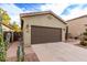 Attached two-car garage with a large driveway and desert landscaping at 42577 W Rosalia Dr, Maricopa, AZ 85138