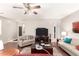 Inviting living room features a ceiling fan, wood flooring, two sofas, and a warm color scheme at 42577 W Rosalia Dr, Maricopa, AZ 85138