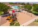 Aerial view of the community playground with a slide and swings near the community pool at 42577 W Rosalia Dr, Maricopa, AZ 85138