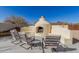 An outdoor fireplace with chairs around a backyard patio ready for entertaining at 44706 N 10Th Way, New River, AZ 85087