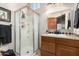 Bright bathroom featuring a stand-up shower with glass door and a wood vanity with sink at 44706 N 10Th Way, New River, AZ 85087