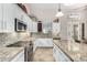 Bright kitchen featuring white cabinetry, stainless steel appliances, granite countertops and tile floors at 44706 N 10Th Way, New River, AZ 85087