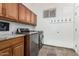 Laundry room with modern washer, dryer, and wooden cabinets, creating a functional space at 44706 N 10Th Way, New River, AZ 85087