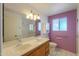 Double sink bathroom with bright lighting, accessible grab bars, and tiled floors at 4506 E Arapahoe St, Phoenix, AZ 85044