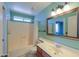 Bright bathroom featuring a shower-tub combo, vanity, and a framed mirror at 4506 E Arapahoe St, Phoenix, AZ 85044