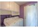 A cozy laundry room featuring a washer and dryer and ample storage space with a door leading to the exterior at 4506 E Arapahoe St, Phoenix, AZ 85044