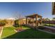 Backyard with a gazebo, artificial grass, and a small tree at 4588 W Suncup Dr, San Tan Valley, AZ 85144