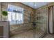 This well-lit bathroom offers a zero-entry glass enclosed shower with handrails and decorative tiling at 4588 W Suncup Dr, San Tan Valley, AZ 85144