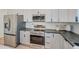 Close up of a kitchen featuring stainless steel appliances and stylish white cabinets with black hardware at 4821 S 12Th St, Phoenix, AZ 85040