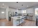 Well-lit kitchen boasts an island with bar stools, white cabinetry, and stainless steel appliances at 4821 S 12Th St, Phoenix, AZ 85040