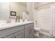 Bathroom with dual sink vanity, combination tub and shower with white tile at 4887 N 184Th Ln, Goodyear, AZ 85395