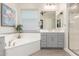 Well-lit bathroom featuring walk-in shower, tub, and dual vanity at 4887 N 184Th Ln, Goodyear, AZ 85395