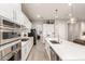 Modern kitchen features white cabinetry, stainless steel appliances, and a center island for meal prep at 4887 N 184Th Ln, Goodyear, AZ 85395