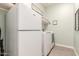 Functional laundry room features a washer, dryer, refrigerator, and ample storage at 4887 N 184Th Ln, Goodyear, AZ 85395