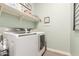 Laundry room with washer and dryer, shelving, and a decorative 'Restore my soul' sign at 4887 N 184Th Ln, Goodyear, AZ 85395