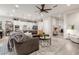 Open-concept living room flows seamlessly into the kitchen, featuring stylish furniture and a decorative ceiling fan at 4887 N 184Th Ln, Goodyear, AZ 85395