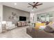 Comfortable living room with a large sofa, hardwood floors, and a modern ceiling fan at 4887 N 184Th Ln, Goodyear, AZ 85395