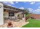 Picturesque backyard with a covered patio, stone fire pit, and lush artificial grass, perfect for outdoor gatherings at 4887 N 184Th Ln, Goodyear, AZ 85395