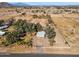 This aerial view shows a home on acreage, surrounded by mature trees with a mountain backdrop at 50880 W Val Vista Rd, Maricopa, AZ 85139