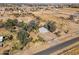 An aerial view displays a rural property surrounded by vast open land and mature trees at 50880 W Val Vista Rd, Maricopa, AZ 85139