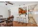 Open dining area with wood floors, three bar stools and a pass through to the kitchen at 50880 W Val Vista Rd, Maricopa, AZ 85139