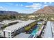 Beautiful aerial view of property featuring a sparkling pool, balconies, and meticulous landscaping against a mountain backdrop at 5455 E Lincoln Dr # 2009, Paradise Valley, AZ 85253