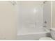 Bright bathroom featuring a shower over tub with white tiled walls and a toilet at 6042 W Warner St, Phoenix, AZ 85043