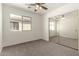 Bright bedroom with lighted ceiling fan, carpeted floors and sliding mirror closet at 6042 W Warner St, Phoenix, AZ 85043