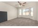 Bright bedroom with neutral carpet and a large window overlooking the backyard at 6042 W Warner St, Phoenix, AZ 85043