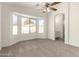 Spacious main bedroom featuring a lighted ceiling fan, bay windows and ensuite entry at 6042 W Warner St, Phoenix, AZ 85043