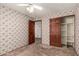 Bedroom with a ceiling fan, flower wallpaper, and dark wood closet doors at 614 W Mcnair St, Chandler, AZ 85225