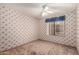 Bedroom with patterned wallpaper, neutral carpet, and a window with blue curtains at 614 W Mcnair St, Chandler, AZ 85225