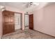 Bedroom with a ceiling fan, patterned wallpaper, carpet flooring, and a closet with dark wood sliding doors at 614 W Mcnair St, Chandler, AZ 85225