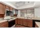 Close up of kitchen with wood cabinets and black appliances at 614 W Mcnair St, Chandler, AZ 85225