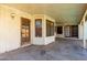 Covered patio featuring a wood door, three windows, and a gray concrete floor at 614 W Mcnair St, Chandler, AZ 85225