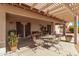 Outdoor patio featuring a pergola, dining table, and lush potted plants, perfect for relaxation at 674 S 231St Dr, Buckeye, AZ 85326