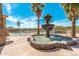 Community pool area features a decorative fountain surrounded by palm trees, offering a tranquil atmosphere at 674 S 231St Dr, Buckeye, AZ 85326