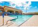 Community lap pool with blue accents, adjacent clubhouse, and plenty of seating at 674 S 231St Dr, Buckeye, AZ 85326