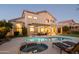 Stunning backyard at dusk with a pool, patio, and well-lit exterior, creating a relaxing and inviting outdoor retreat at 7357 E Rochelle Cir, Mesa, AZ 85207