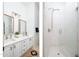 Elegant bathroom featuring double sinks, white cabinetry, and a glass-enclosed shower with marble tiling and modern fixtures at 7357 E Rochelle Cir, Mesa, AZ 85207