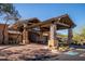 Inviting clubhouse entrance with stone pillars, desert landscaping, and covered entryway for convenient access at 7357 E Rochelle Cir, Mesa, AZ 85207