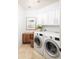 Functional laundry room with modern washer and dryer, wooden accents, and storage cabinets for an organized space at 7357 E Rochelle Cir, Mesa, AZ 85207